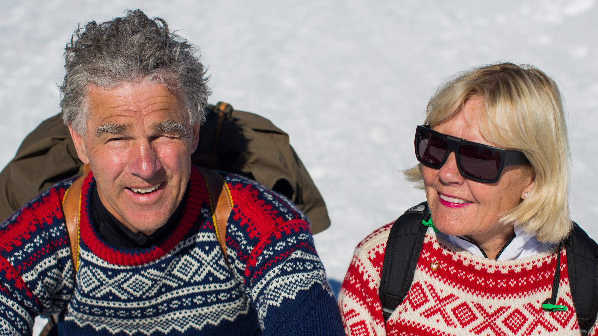 Et elde ektepar i Mariusgensere sitter i solen etter en skitur